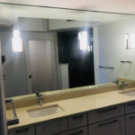 Small master bathroom with wide mirror installation.