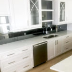 white kitchen with dark backsplash for definition.